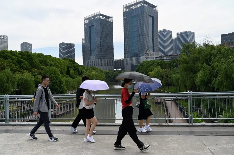 People walk on a street in Lujiazui district in Shanghai, China, on 29 June 2023. (Pedro Pardo/AFP)