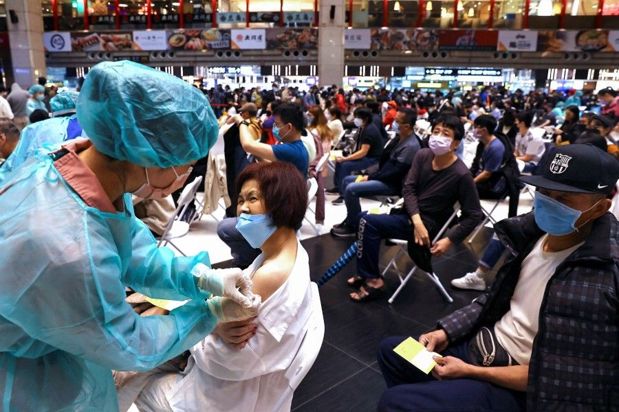 A woman receives a booster shot of the Covid-19 vaccine at Taipei main station ahead of the Chinese New Year in Taipei, Taiwan, 24 January 2022. (Ann Wang/Reuters)