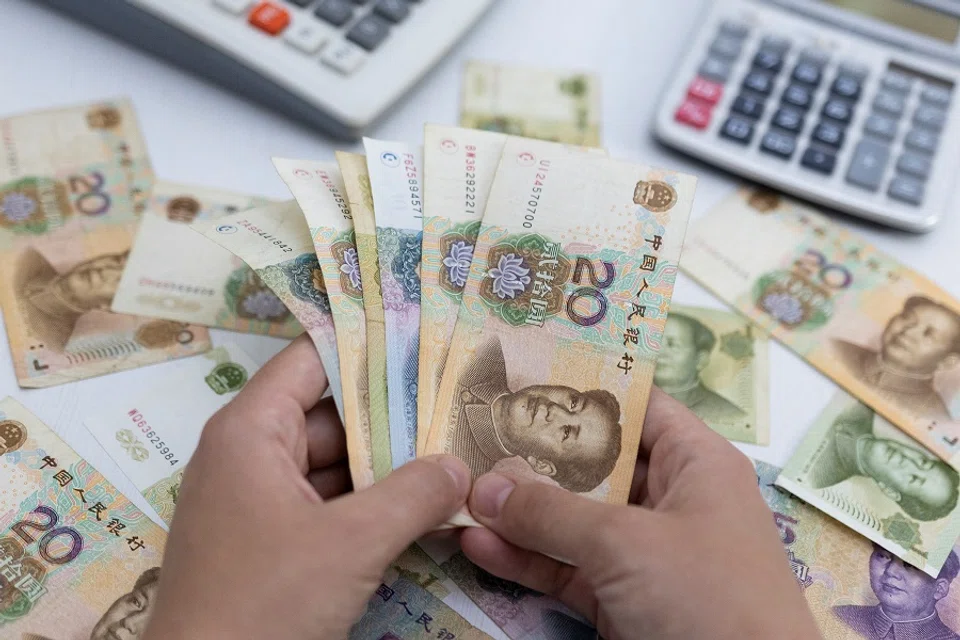 A woman holds Chinese RMB banknotes in this illustration taken on 30 May 2022. (Dado Ruvic/Illustration/Reuters)