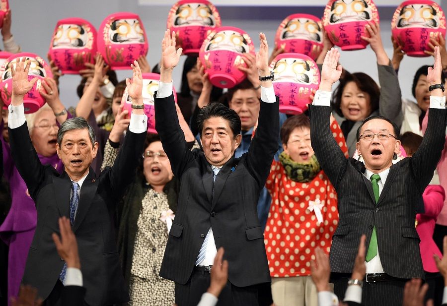 This file photo taken on 8 March 2015 shows Japan's Prime Minister and ruling Liberal Democratic Party (LDP) president Shinzo Abe (front, centre) shouting "banzai" with deputy president Masahiko Komura (front, left) and secretary-general Sadakazu Tanigaki (front, right) at the end of the LDP convention in Tokyo, Japan. (Toshifumi Kitamura/AFP)