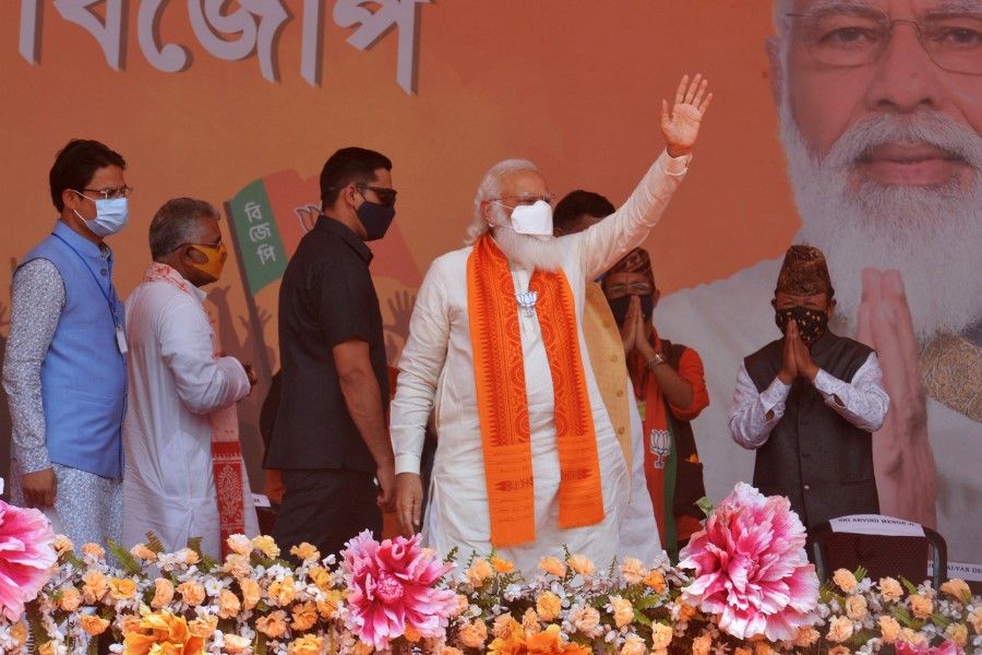 Indian Prime Minister Narendra Modi (centre) waves to supporters in a rally meeting at Kawakhali on the outskirts of Siliguri on 10 April 2021. (Diptendu Dutta/AFP)