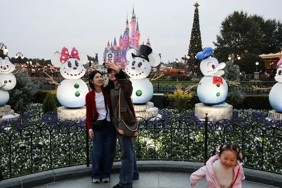 Park visitors take photos with Disney-themed Christmas decorations at Shanghai Disneyland in Shanghai, China, 24 November 2025. (Go Nakamura/Reuters)