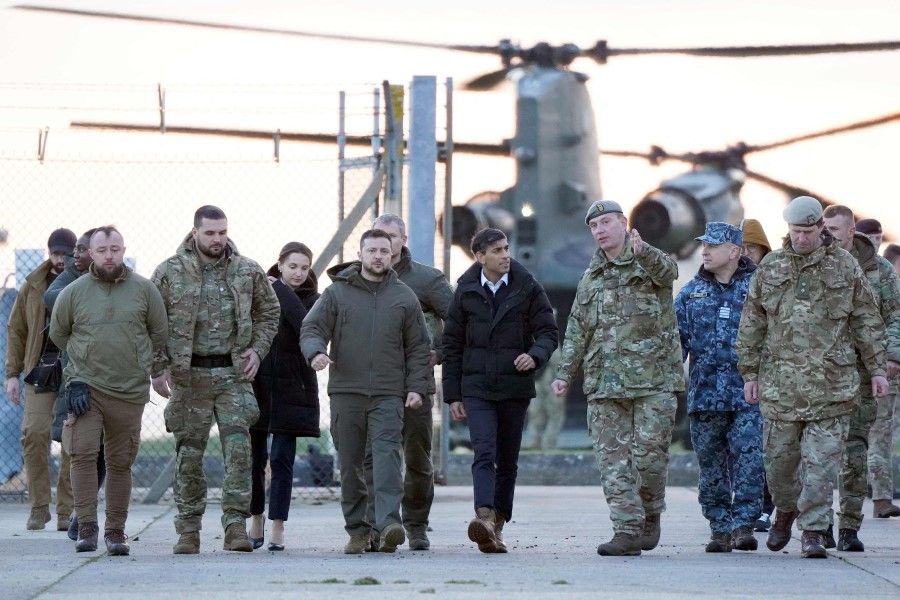 Ukraine's President Volodymyr Zelenskyy (centre left) and Britain's Prime Minister Rishi Sunak (centre right) arrive to meet Ukrainian troops being trained to command Challenger 2 tanks at a military facility in Lulworth, Dorset, in southern England, on 8 February 2023.(Andrew Matthews/AFP)