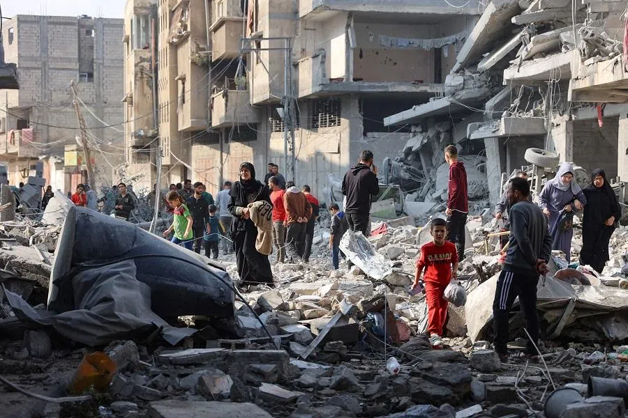 Palestinians walk amid the destruction following an Israeli strike in Jabalia in the northern Gaza Strip on 10 November 2024. Israel’s military has been conducting a sweeping air and ground assault in northern Gaza since 6 October 2024, particularly around Jabalia, Beit Lahia and Beit Hanoun, saying it aims to prevent Hamas regrouping.