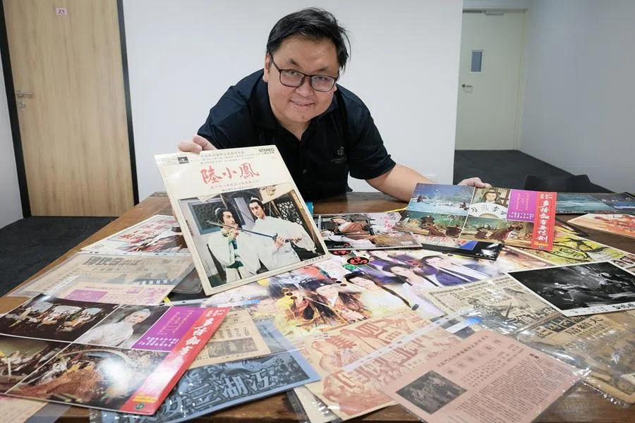 Collector Su Zhangkai, with his wuxia posters, vinyl records, magazines, lobby cards and movie flyers ranging from the 1940s to mid 1980s, in a shot taken on 14 April 2026.