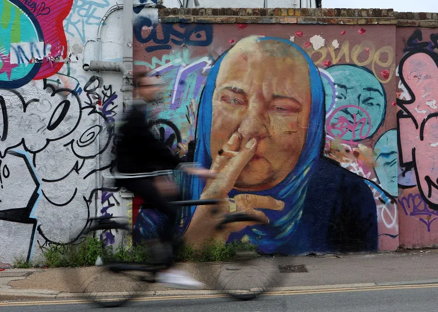 A cyclist rides past a mural depicting late Irish singer Sinead O'Connor, following her recent death, in London, Britain, 4 August 2023. (Susannah Ireland/Reuters)