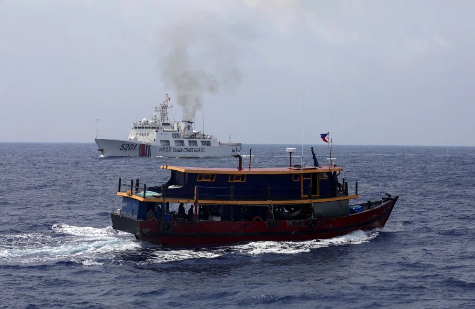 A Philippine supply boat sails near a Chinese Coast Guard ship during a resupply mission for Filipino troops stationed at a grounded warship in the South China Sea, on 4 October 2023. (Adrian Portugal/Reuters)