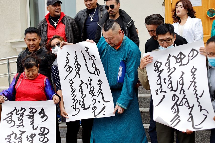 Demonstrators, holding signs with Mongolian script, protest against China's changes to school curriculums that remove Mongolian language from core subjects, outside the Mongolian Ministry of Foreign Affairs in Ulaanbaatar, Mongolia, 31 August 2020. (Anand Tumurtogoo/Reuters)