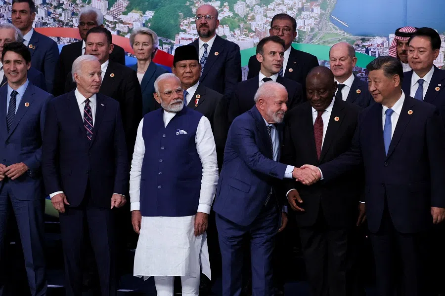 Brazil’s President Luiz Inacio Lula da Silva shakes hands with China’s President Xi Jinping, while world leaders gather for a group photo during the G20 summit in Rio de Janeiro, Brazil, on 19 November 2024. (Leah Millis/Reuters)