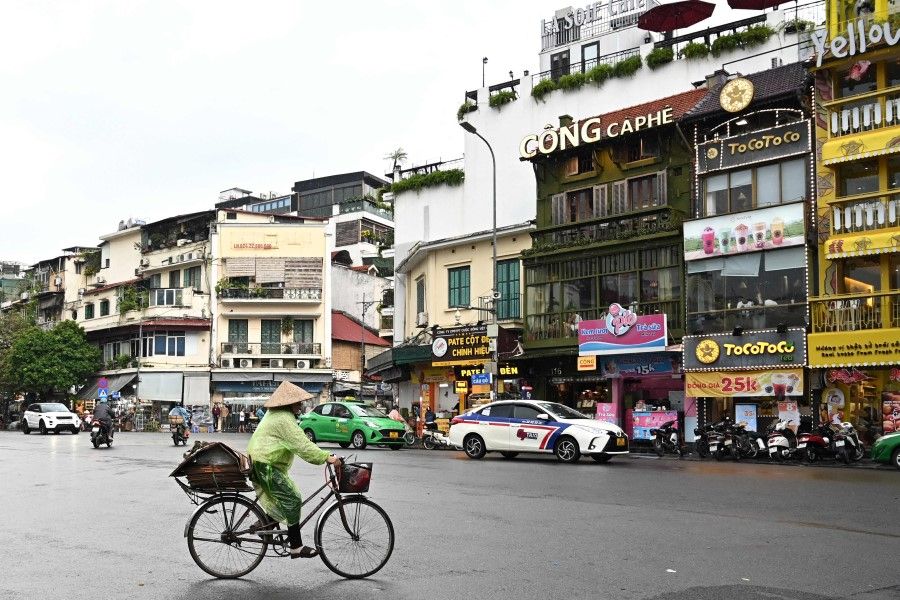 A woman rides a bicycle on the street in Hanoi on 25 September 2023 (Nhac Nguyen/AFP)