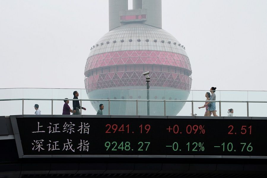 People walk by an electronic board showing the Shanghai and Shenzhen stock indexes, on a pedestrian overpass at Lujiazui financial district in Shanghai, China, 16 May 2019. (Aly Song/File Photo/Reuters)