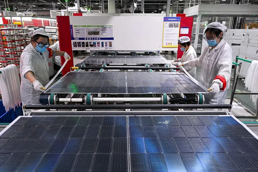 This photo taken on 23 January 2025 shows workers producing photovoltaic (PV) modules for solar panels in a factory in Suqian, Jiangsu province, China. (AFP)