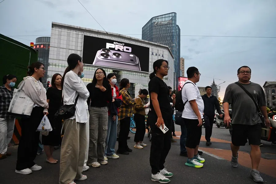 People wait to cross a road in Beijing, China, on 16 September 2025. (Greg Baker/AFP)