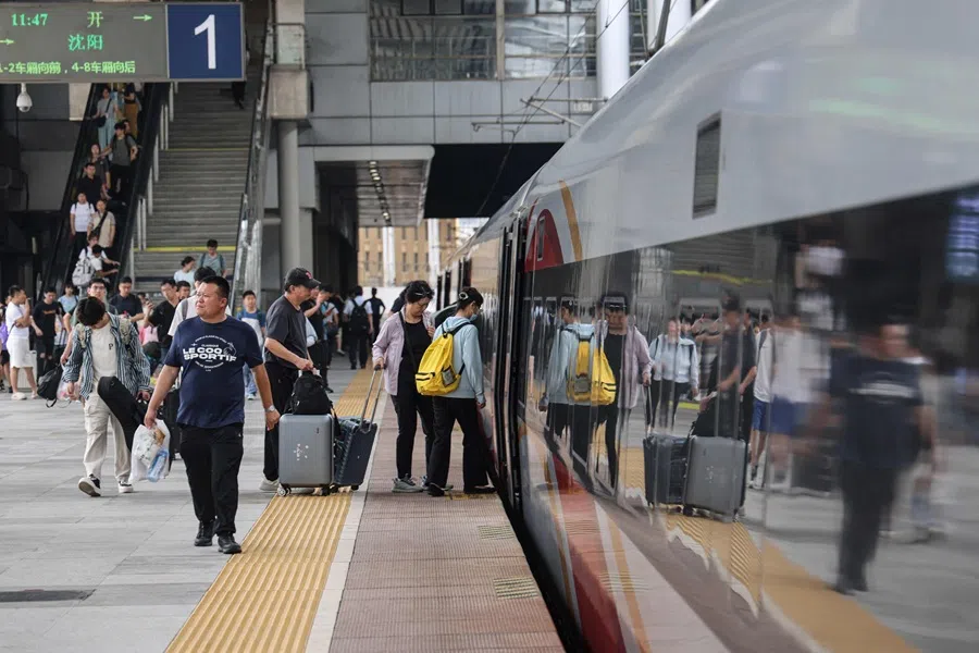 Passengers board a high speed train at a railway station in Dalian, Liaoning province, China, on 1 July 2025. (AFP)