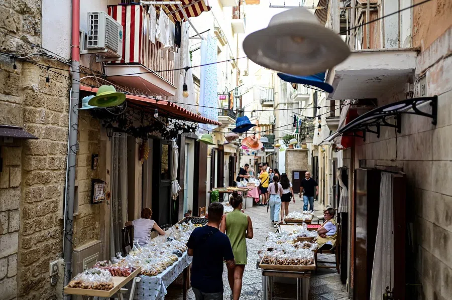 Street vendors sit behind their stalls of homemade orecchiette pasta in in Bari Vecchia, Apulia, Italy, on 11 June 2024. (Piero Cruciatti/AFP)