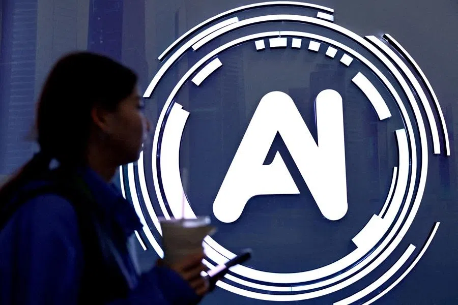 A woman walks past a sign reading "AI" at the World Internet Conference in Wuzhen, Tongxiang city, Zhejiang province, China, on 8 November 2025.