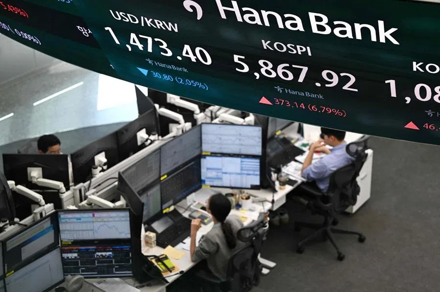 Currency dealers monitor exchange rates as a screen shows South Korea's benchmark stock index (KOSPI) and the Korean won/US dollar exchange rate in a foreign exchange dealing room at the Hana Bank headquarters in Seoul on 8 April 2026. (Jung Yeon-je/AFP)