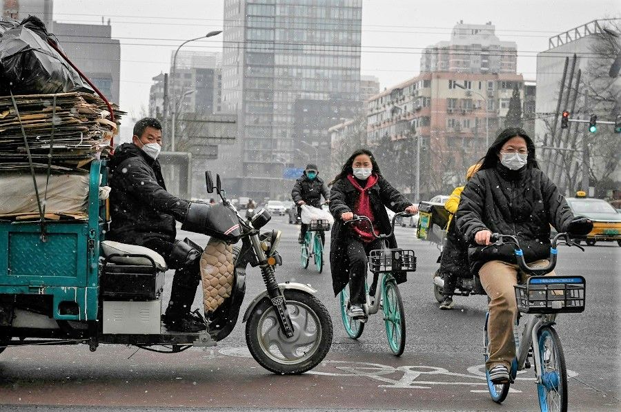 People ride bicycles on a street in Beijing, China, on 9 February 2023. (Jade Gao/AFP)