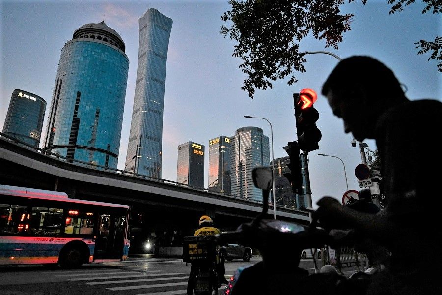 People wait for traffic lights at the central business district in Beijing, China, on 23 July 2023. (Jade Gao/AFP)