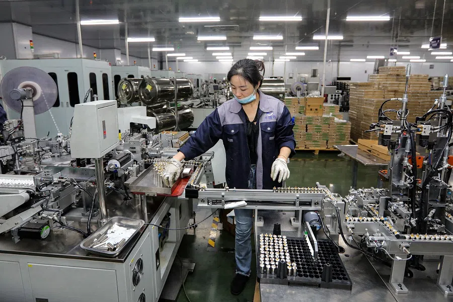 An employee works at a company manufacturing lithium batteries in Huaibei, Anhui province, China, on 26 November 2024. (AFP)