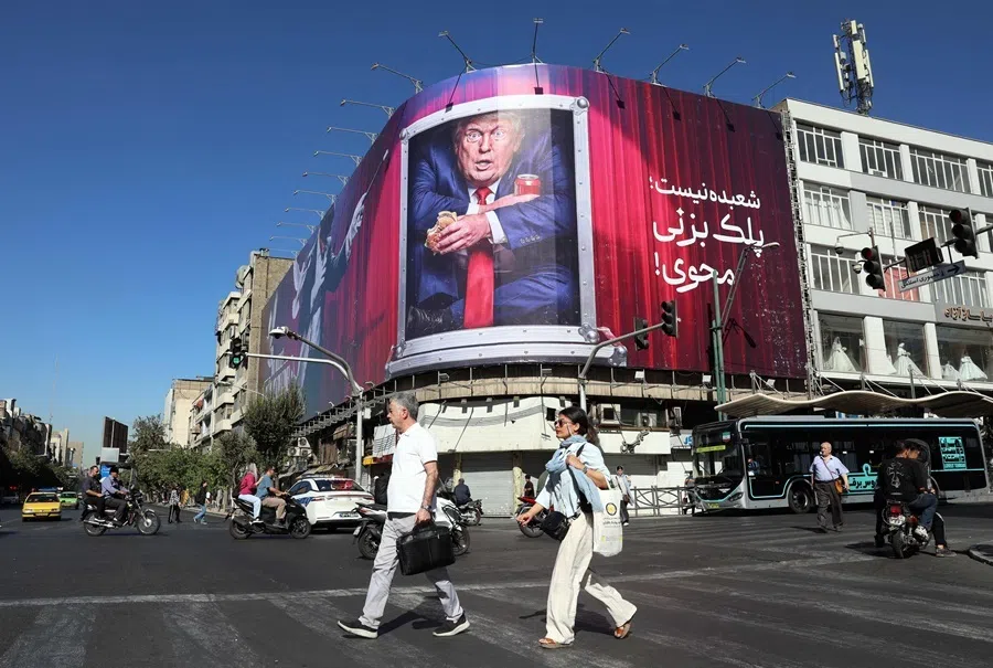 Iranians walk past an anti-Trump billboard along a street in Tehran on 23 September 2026.