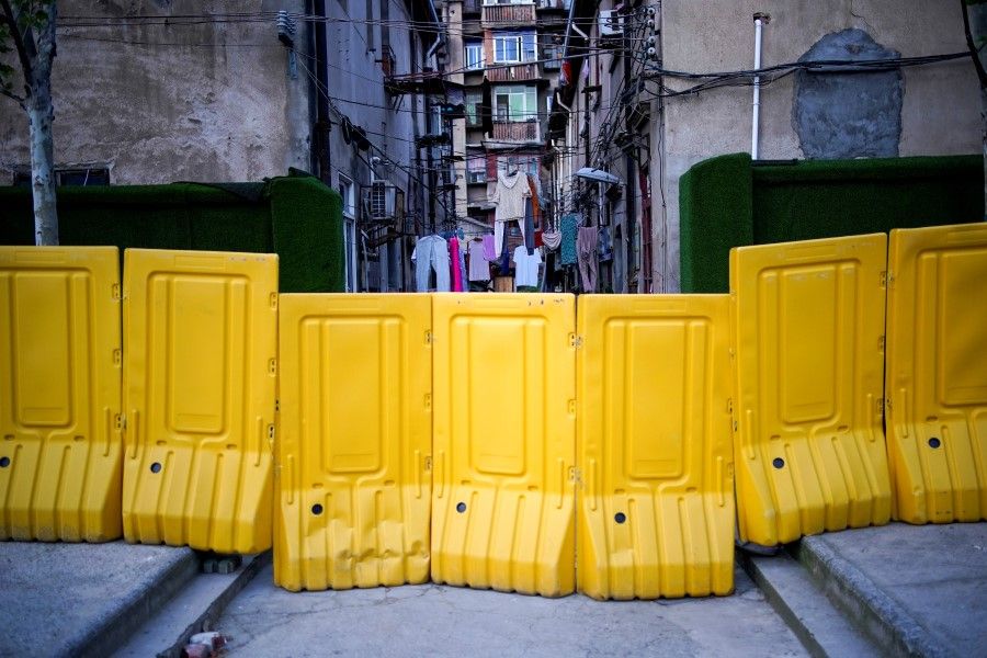 Lines of laundry are seen hanging between apartments behind barricades, which have been built to block buildings from a street, after the lockdown was lifted in Wuhan, April 14, 2020. (Aly Song/REUTERS)