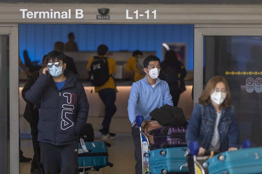 In this photo taken on 2 February 2020, travellers arrive at LAX Tom Bradley International Terminal wearing medical masks for protection against the coronavirus outbreak. Foreign nationals who have been in China in the last two weeks and are not immediate family members of US citizens or permanent residents will be barred from entering the US. (David McNew/Getty Images/AFP)