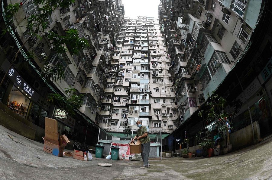 This file photo taken on 22 March 2022 shows a woman collecting cardboard at a housing estate in Hong Kong.(Peter Parks/AFP)