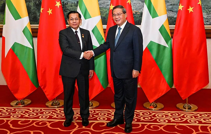 This handout picture taken on 6 November 2024 and released by the Myanmar Military Information team shows Myanmar’s military chief Min Aung Hlaing (L) shaking hands with China’s Premier Li Qiang (R) ahead of a dinner reception during the Greater Mekong Subregion summit in Kunming, southern China’s Yunnan province. (Handout/Myanmar Military Information Team/AFP)
