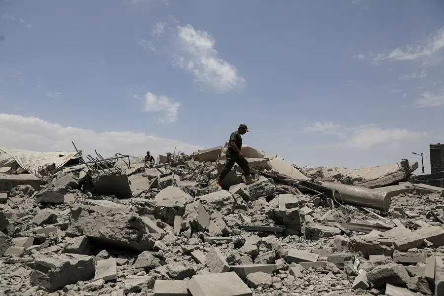 A police trooper walks on the rubble of a building destroyed by US air strikes in Sanaa, Yemen, on 27 April 2025. (Khaled Abdullah/Reuters)
