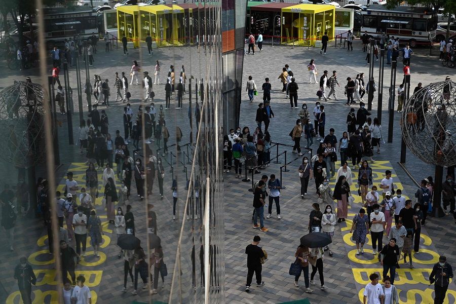 People walk through a shopping mall in Beijing, China, on 30 April 2023. (Greg Baker/AFP)