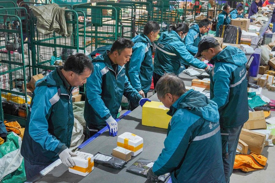 Workers sort packages for delivery ahead of the Singles' Day shopping festival at a logistics centre in Zouping, Shandong province, China, on 10 November 2023. (AFP)