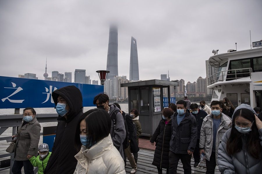 People wearing protective masks disembark from a ferry after crossing the Huangpu River in Shanghai, China, on 12 February 2021. (Qilai Shen/Bloomberg)