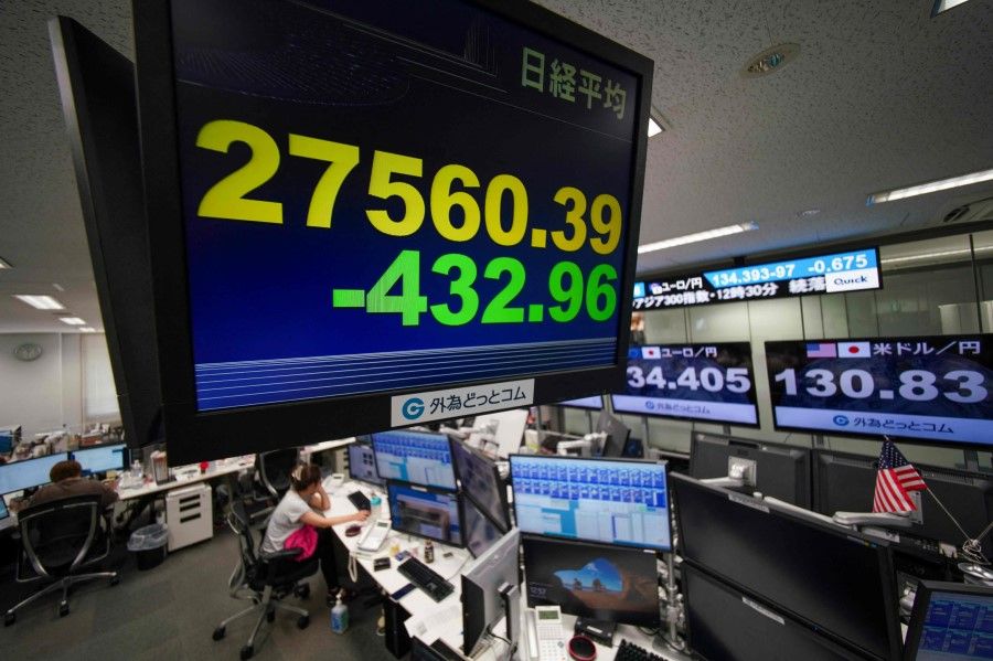 An electronic quotation board displays the numbers of the Tokyo Stock Exchange (foreground) and the yen's rate against the US dollar (right) at a foreign exchange brokerage in Tokyo on 2 August 2022. (Kazuhiro Nogi/AFP)