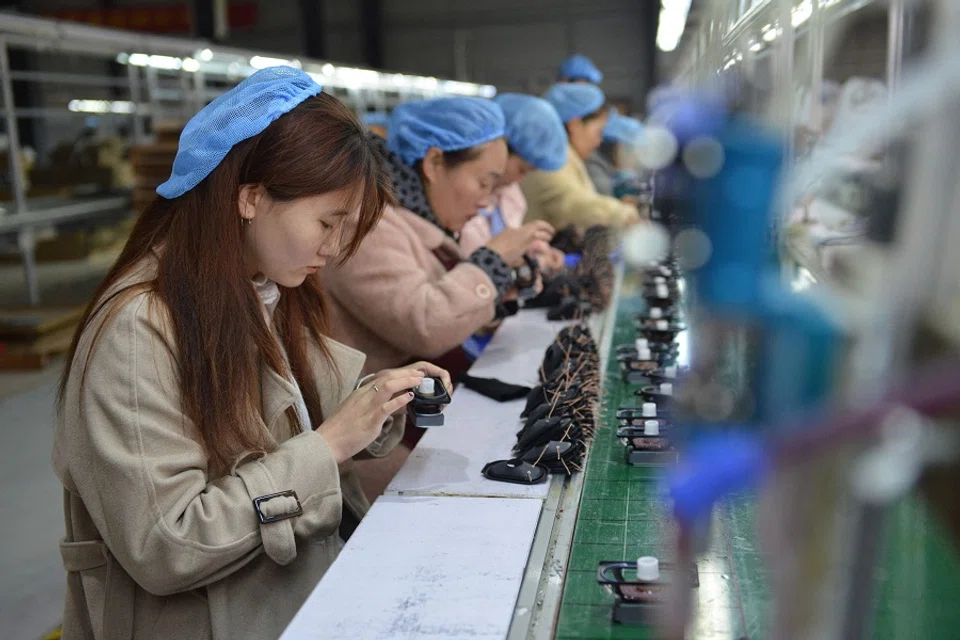 Employees work on an assembly line producing speakers at a factory in Fuyang, Anhui province, China, on 31 March 2023. (AFP)