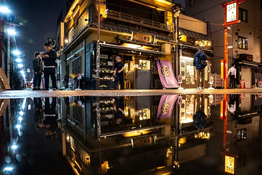 People walk on a shopping street at the Asakusa district near Sensoji Temple, a popular tourist location in Tokyo during evening hour on 30 May 2025. (Philip Fong/AFP)