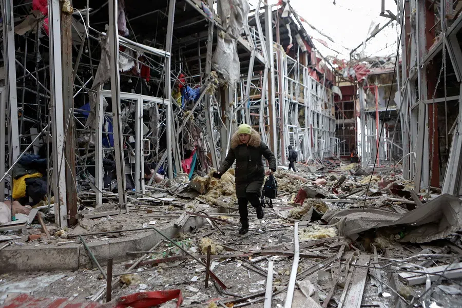 A woman walks on debris at a market which was hit by a Russian drone strike, amid Russia’s attack on Ukraine, in Kharkiv, Ukraine, 6 February 2025. (Sofiia Gatilova/Reuters)