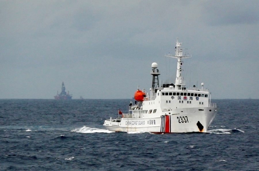 A Chinese Coast Guard vessel (right) passes in the South China Sea, 13 June 2014. (Nguyen Minh/Reuters)