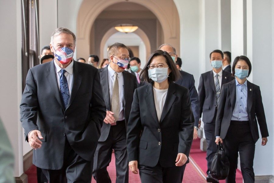 This handout picture taken and released by Taiwan's Presidential Office on 3 March 2022 shows Taiwan's President Tsai Ing-wen (centre) walking with former US secretary of state Mike Pompeo (left) during his visit to the Presidential Office in Taipei. (Handout/Presidential Office/AFP)
