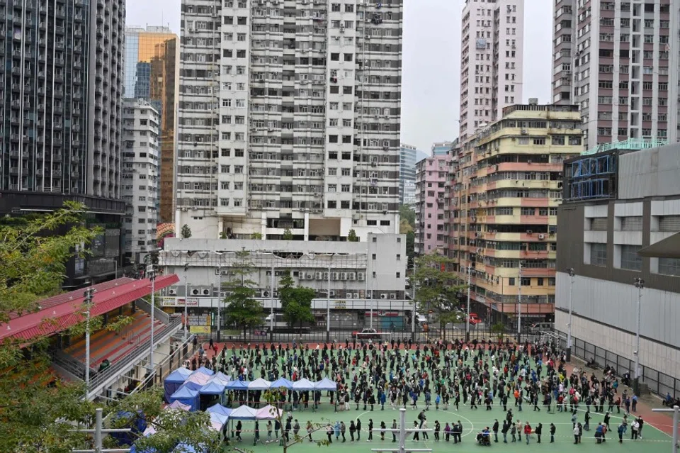 People queue at a mobile specimen collection station for Covid-19 testing in Hong Kong's Mongkok district on 10 February 2022 as authorities scrambled to ramp up testing capacity following a record high number of new infections. (Peter Parks/AFP)