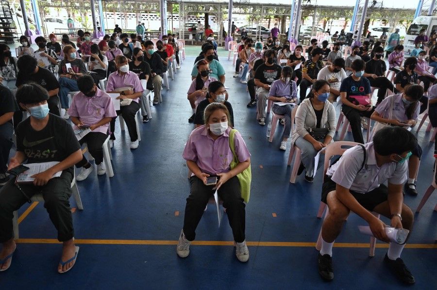 High school students wait to be administered a dose of the Pfizer vaccine for the Covid-19 coronavirus at Prachaniwet Secondary School in Bangkok on 4 October 2021. (Lillian Suwanrumpha/AFP)