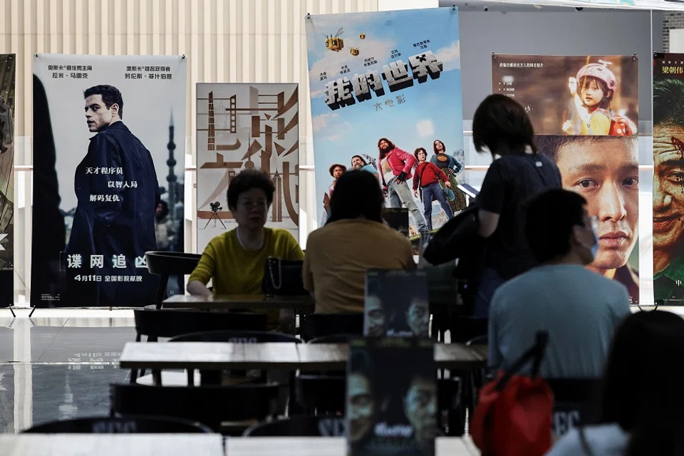 People sit at tables while waiting for the showtime at a movie theatre in Shanghai, China, on 11 April 2025. (Go Nakamura/Reuters)