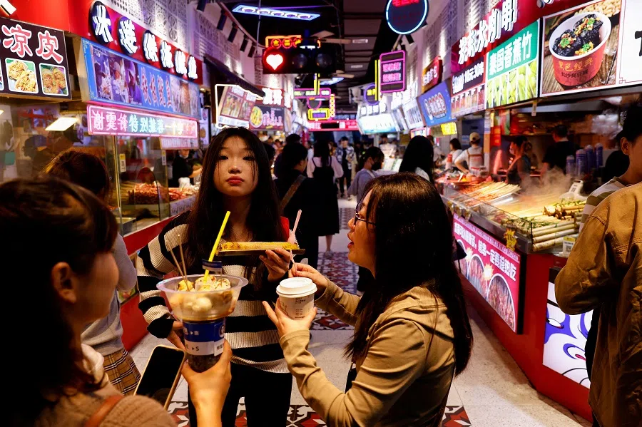 People shop and eat at a mall in Hangzhou, China, on 22 September 2023. (Ann Wang/Reuters)