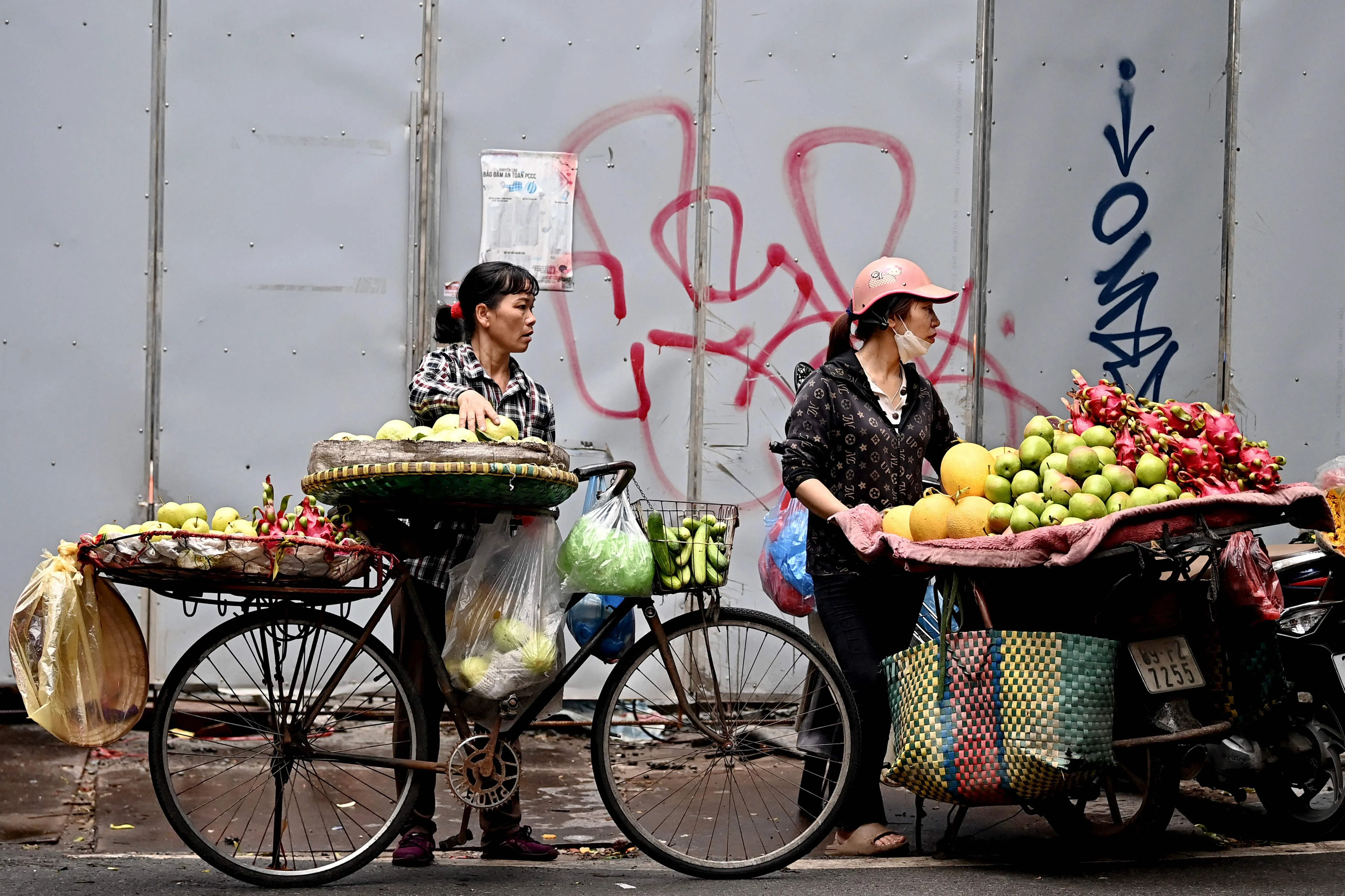 Fruit vendors wait on the street for customers in Hanoi on 19 July 2024. (Nhac Nguyen/AFP)