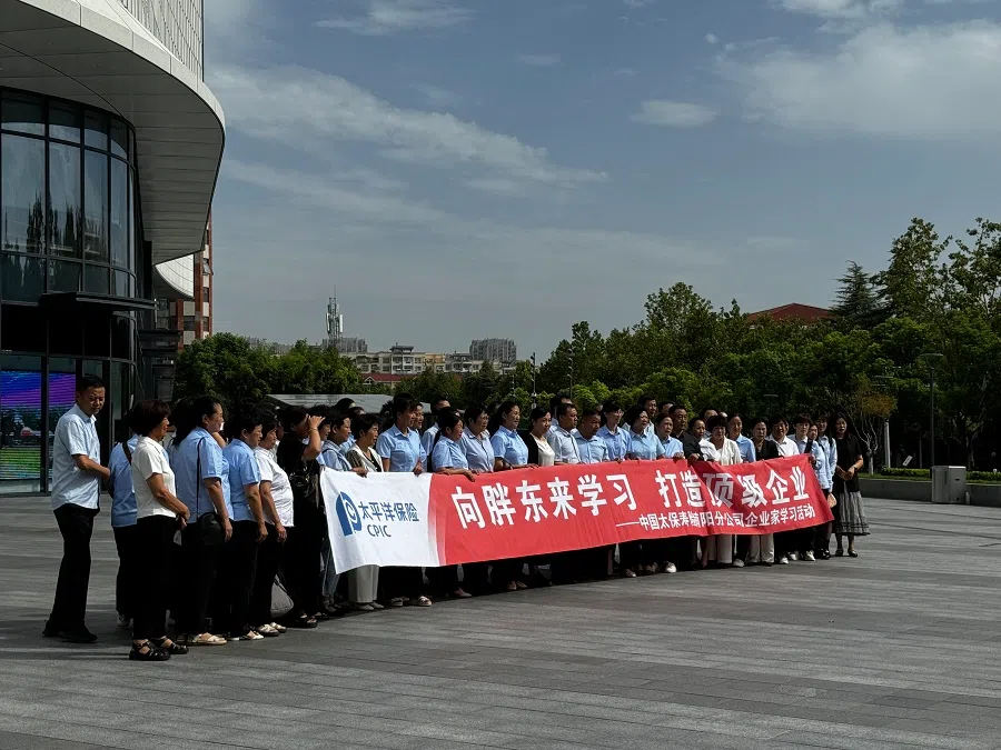 A study group poses for a photograph outside the Pang Dong Lai Angel City supermarket.
