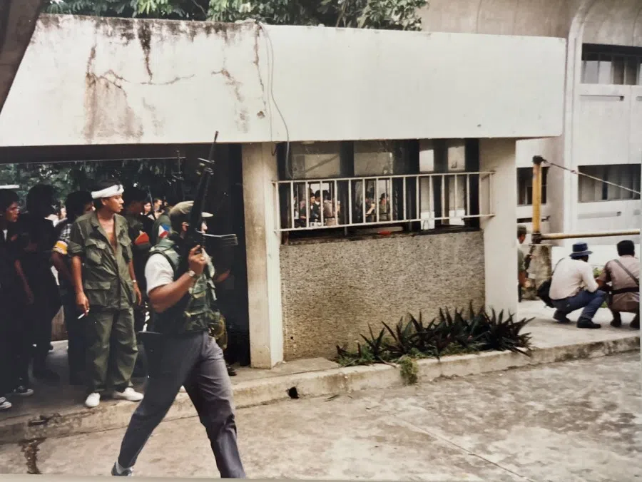 Government troops and police are deployed amid an exchange of fire as a faction of the Philippine military revolts and seizes a television station, April 1987.