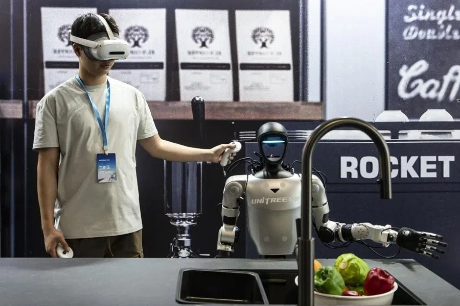 A employee and a Unitree Robotics G1 humanoid robot during a demonstration at the company's headquarters in Hangzhou, China, on Tuesday, June 2, 2026. China is pitching itself as the global fulcrum for the next phase of artificial intelligence and a legion of robotics companies is lining up initial public offerings to test investor appetite. Photographer: Qilai Shen/Bloomberg