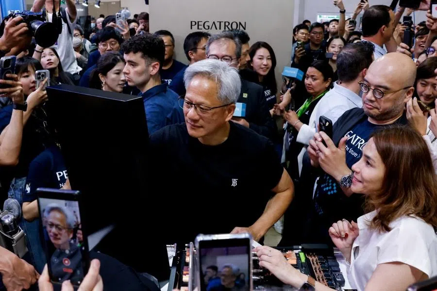Nvidia’s CEO, Jensen Huang, signs his name at the Pegatron booth while visiting Computex in Taipei, Taiwan, on 20 May 2025. (Ann Wang/Reuters)