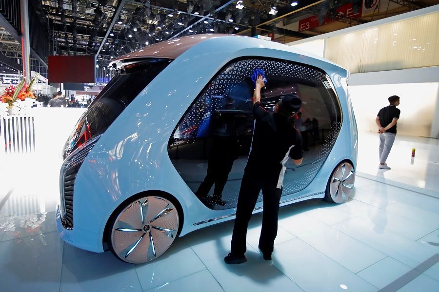 A staff member cleans a Hongqi self-driving concept car at the Beijing International Automotive Exhibition, in Beijing, China, 26 September 2020. (Thomas Peter/Reuters)