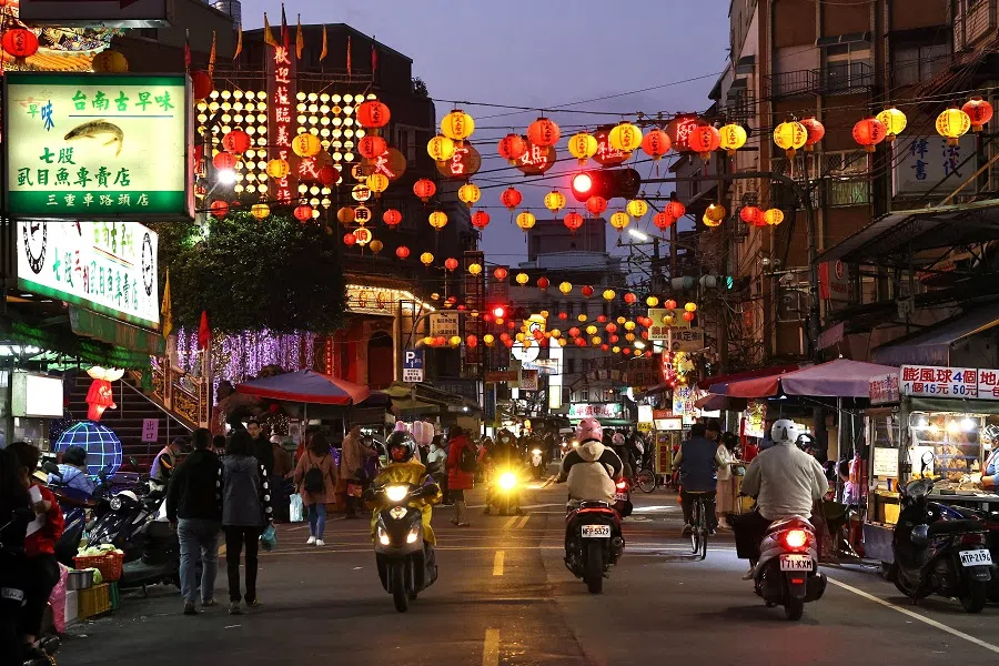 People pass by lit up lanterns during the Lunar New Year holiday in Taipei, Taiwan, 14 February 2021. (Ann Wang/Reuters)